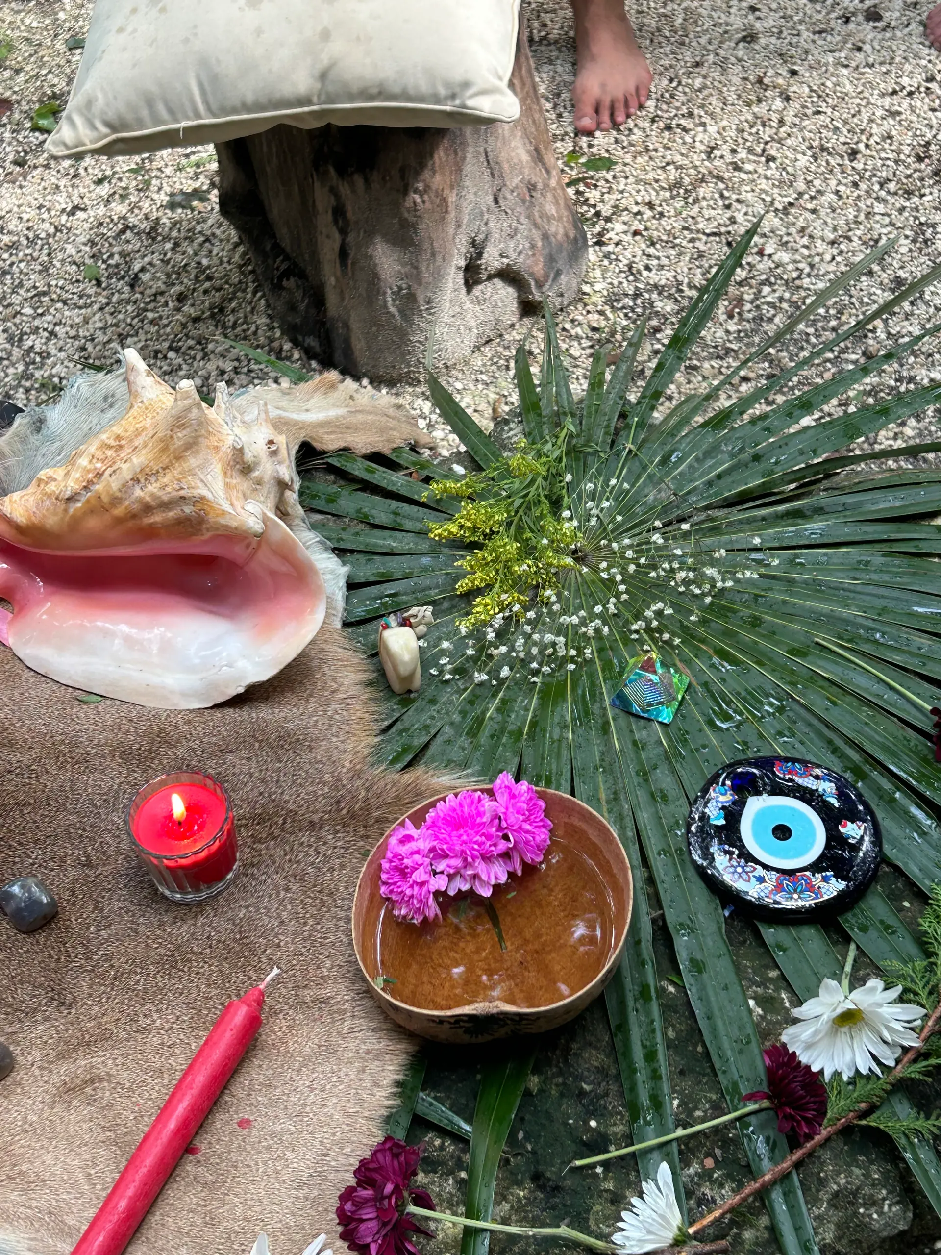 Altar con caracol, velas, flores y hojas de palma