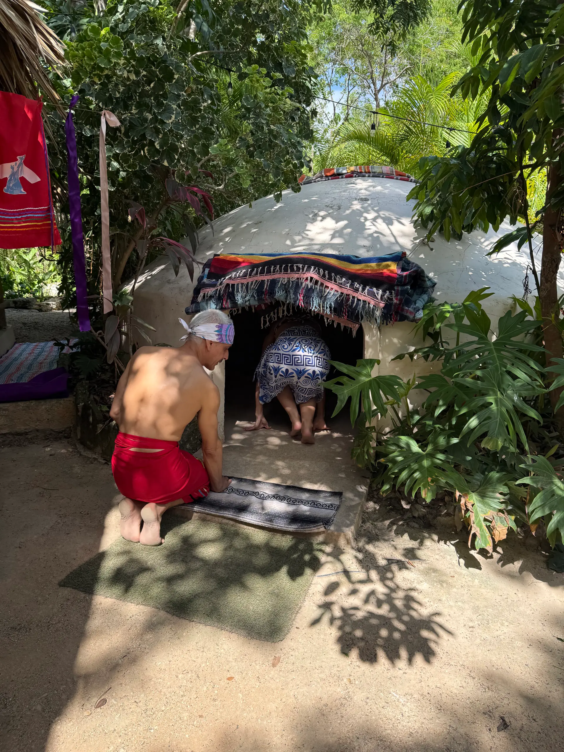 Entrando al temazcal a gatas, bajo el sarape que cubre la boca