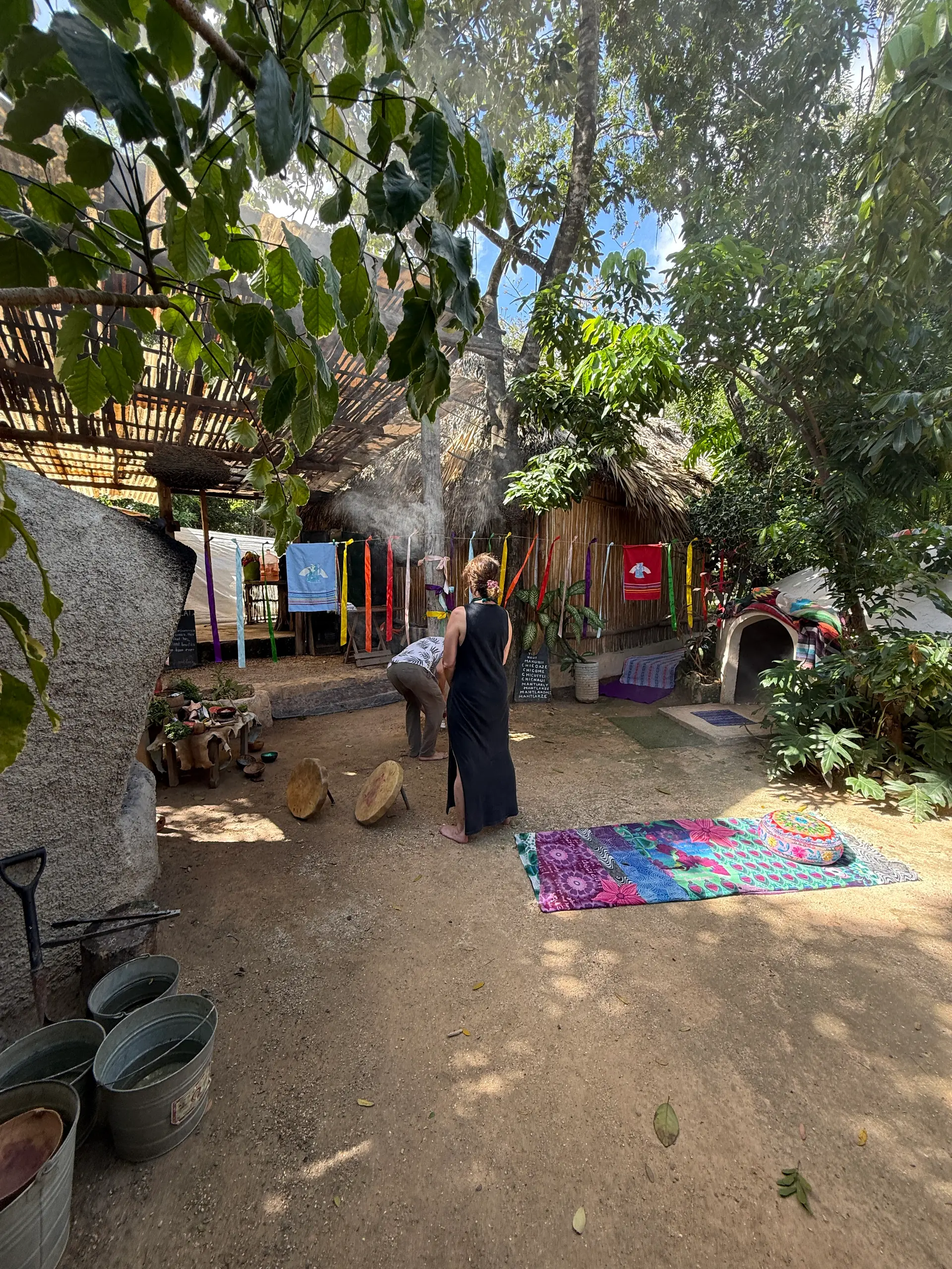 El patio con el domo al fondo, los tapetes de colores y los listones entre los árboles