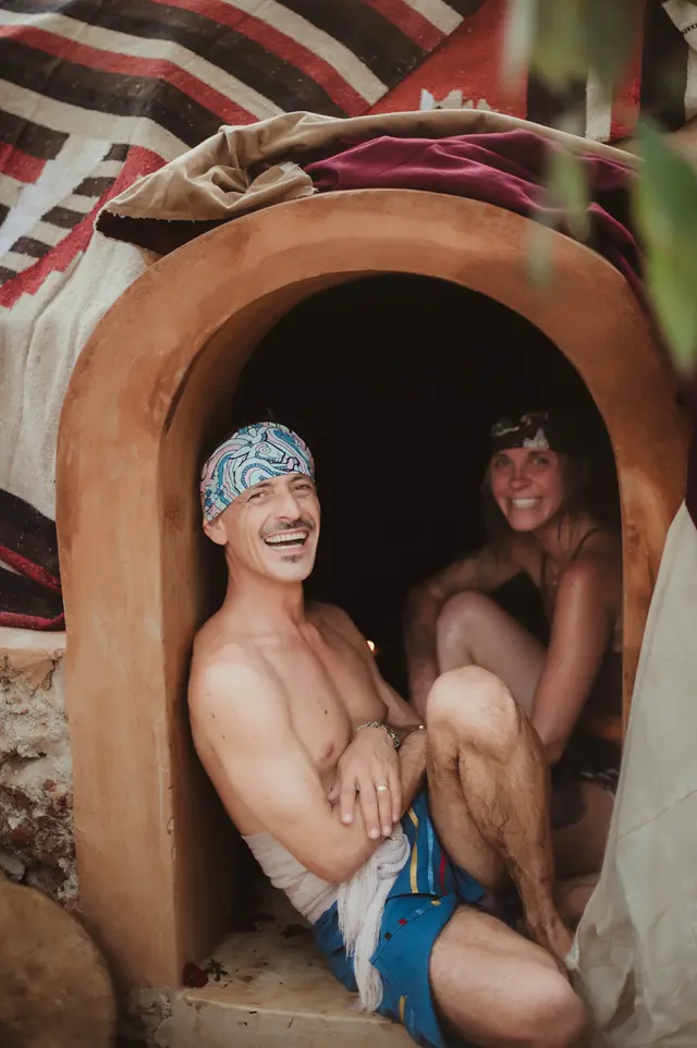 Dos personas en la boca del temazcal, antes de entrar