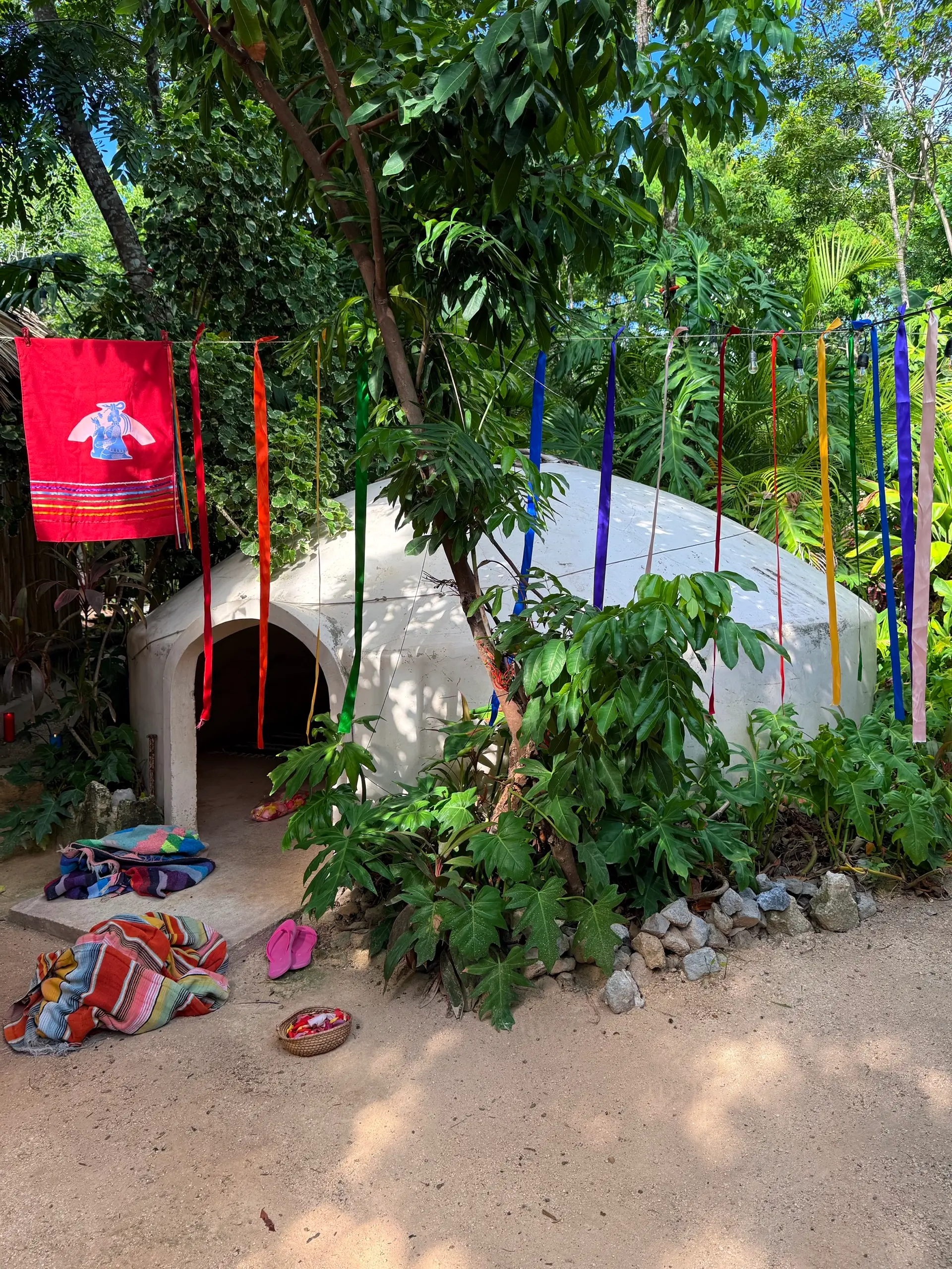 El sendero hacia el temazcal entre listones de colores y un banderín rojo